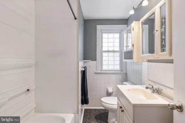 a bathroom with a sink a toilet and a window