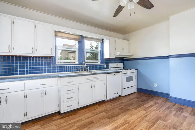 a kitchen with a refrigerator a stove and white cabinets