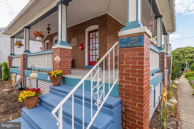 a view of a house with a yard and potted plants