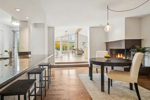 a view of a dining room with furniture a chandelier and wooden floor