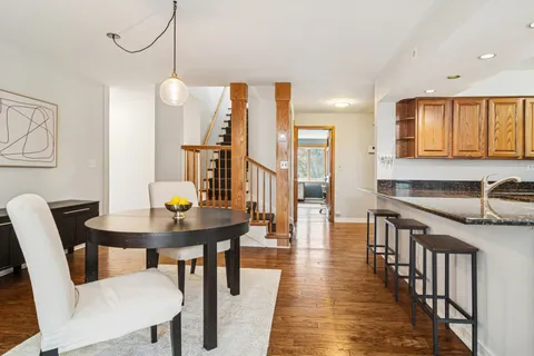 a kitchen with stainless steel appliances a table chairs and a wooden cabinets