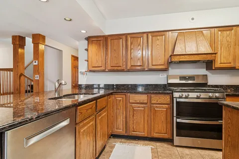 a kitchen with stainless steel appliances granite countertop a stove a sink and a microwave
