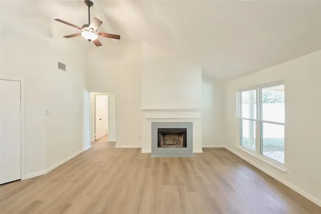 wooden floor fireplace and windows in an empty room