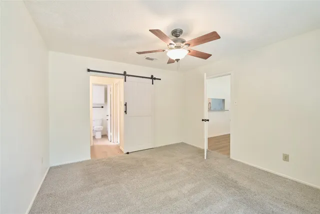 a view of a room with a ceiling fan and a window