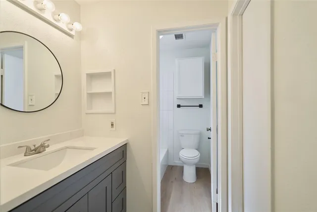 a bathroom with a sink a toilet and a mirror