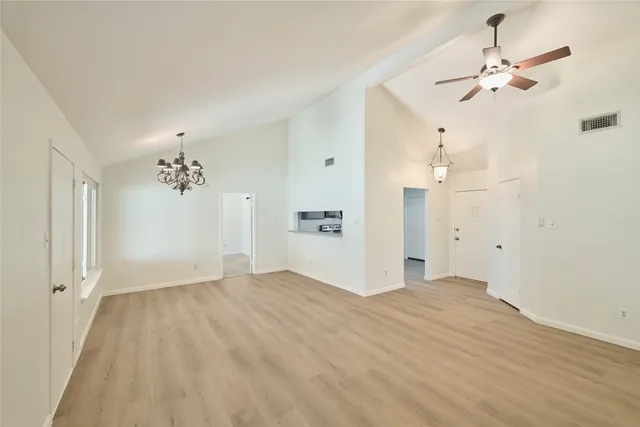 a view of a livingroom with a chandelier fan and wooden floor
