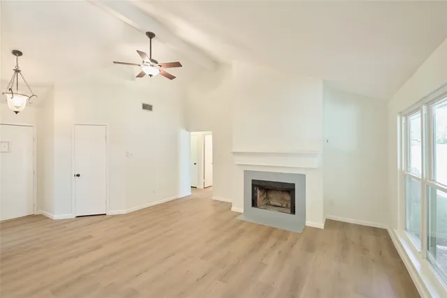a view of empty room with fireplace and fan