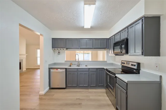 a kitchen with stainless steel appliances a sink stove and cabinets