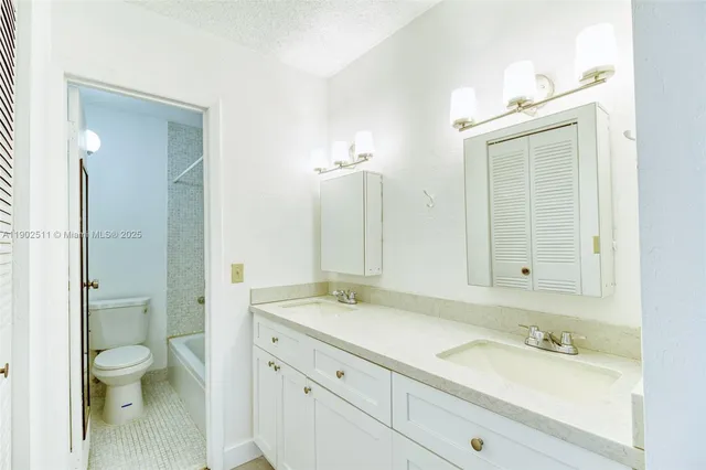 a bathroom with a sink a toilet and a large mirror