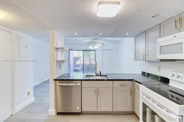 a kitchen with kitchen island granite countertop a sink and cabinets