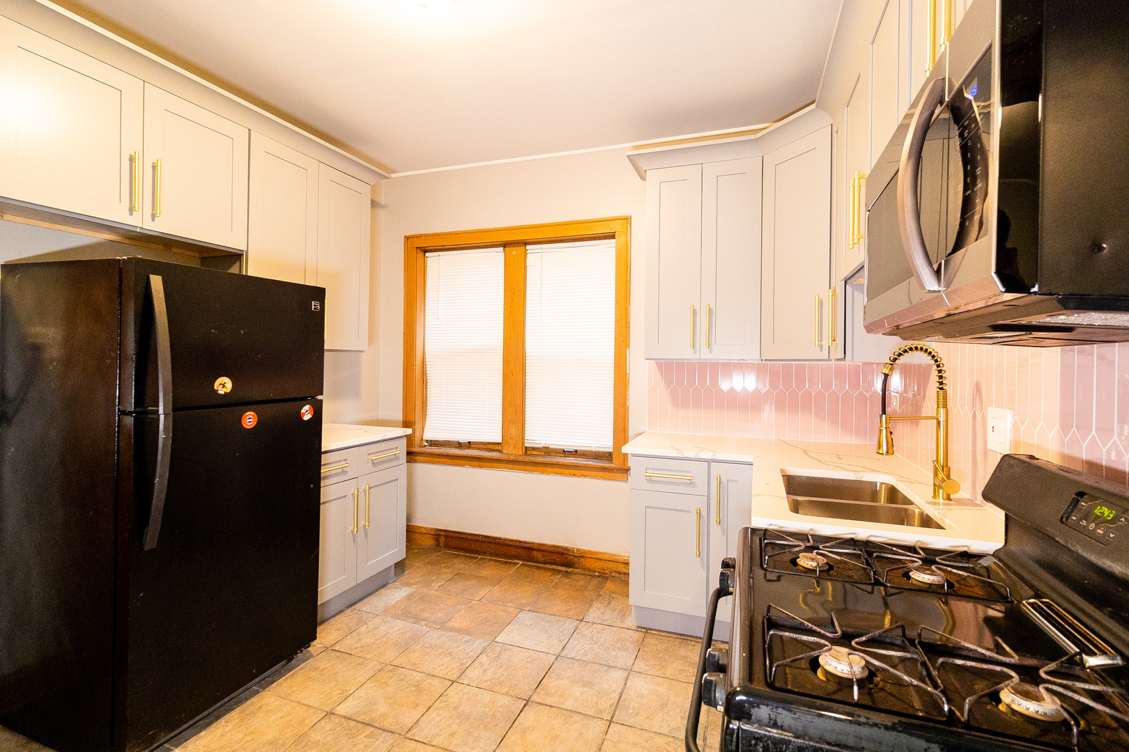 2115 Wesley Avenue, Unit 1 Berwyn, IL 60402 - Photo 3 of 8 a kitchen with a refrigerator and a stove top oven