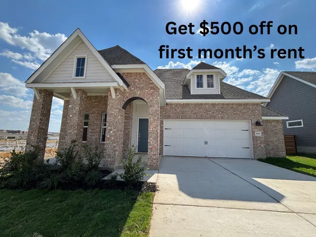 a front view of a house with a garden and garage
