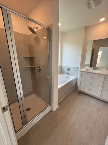 an empty room with wooden floor and natural light