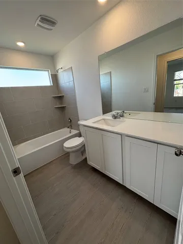 a spacious bathroom with a toilet sink and mirror