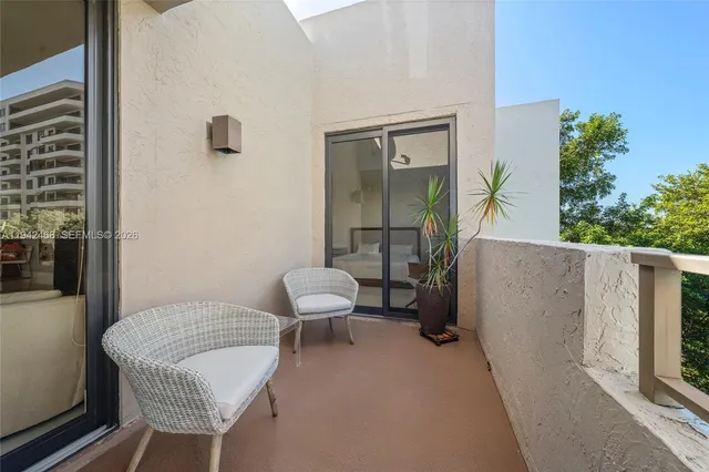 a balcony with couple of couches and potted plants