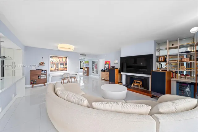 a living room with furniture a flat screen tv and a fireplace