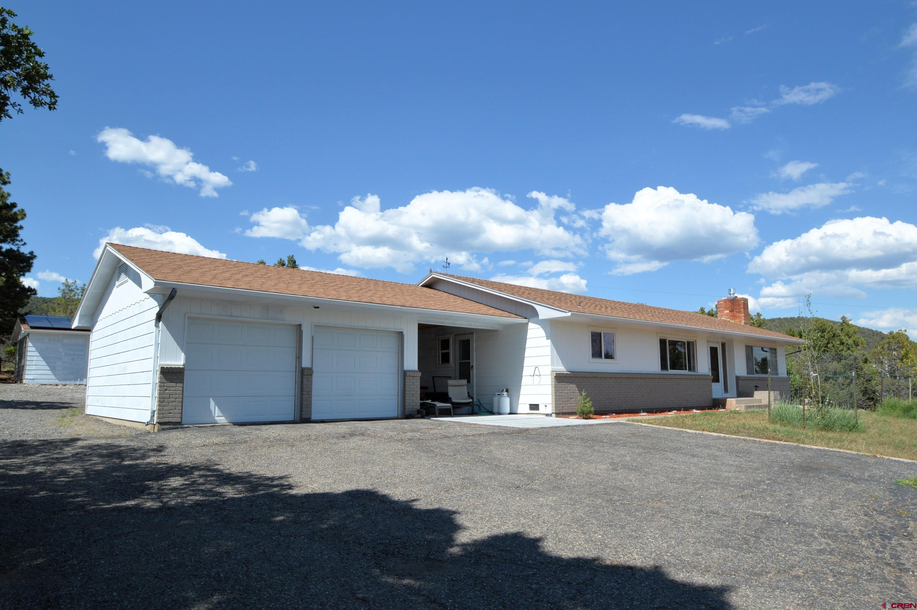 22755 Uintah Road Cedaredge, CO 81413 - Photo 2 of 21 a view of a white house with a yard