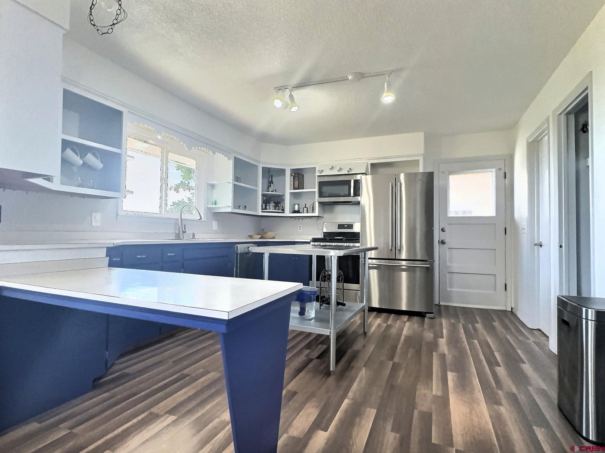 22755 Uintah Road Cedaredge, CO 81413 - Photo 6 of 21 a kitchen with stainless steel appliances a stove refrigerator and wooden floor