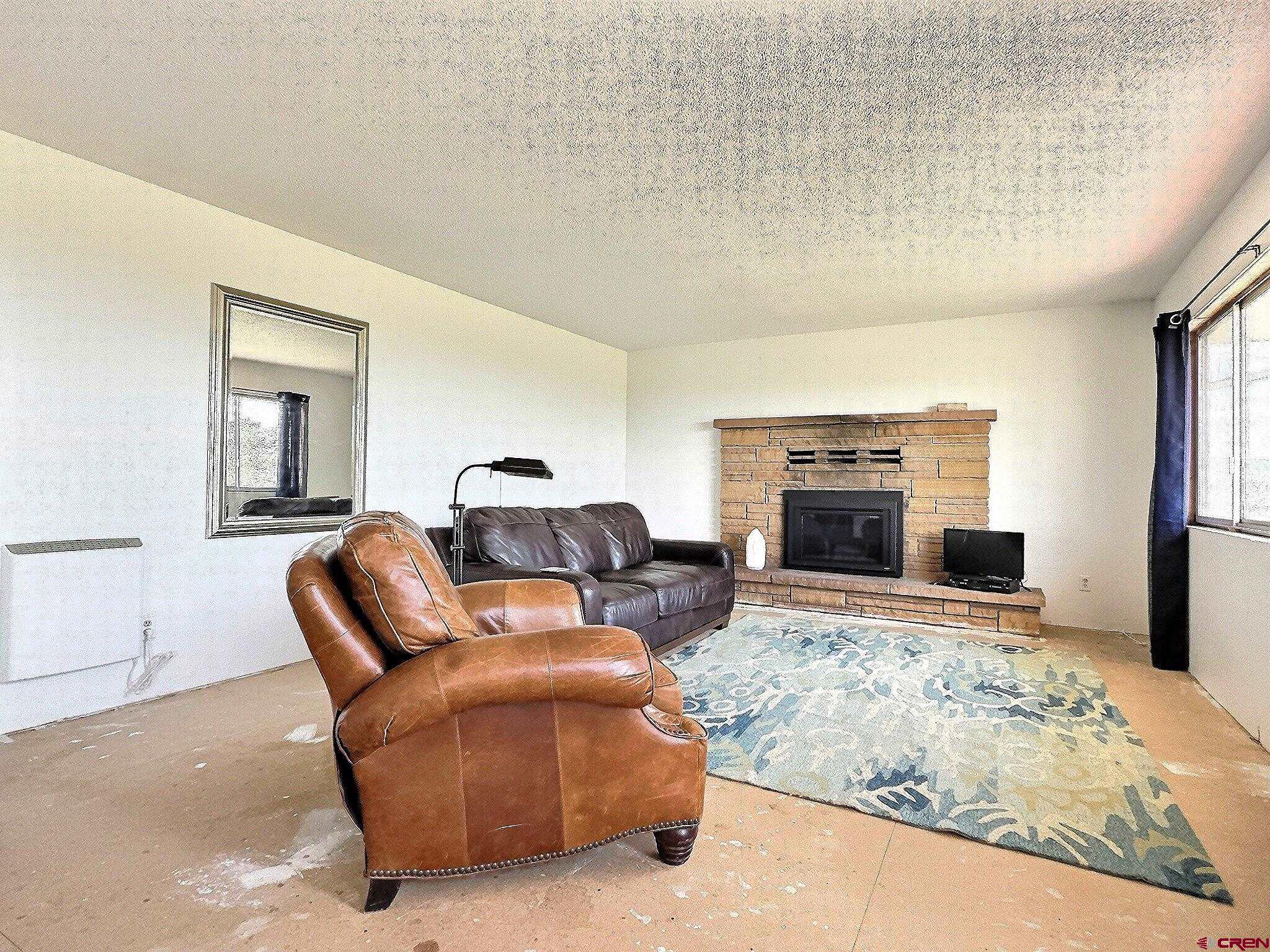 22755 Uintah Road Cedaredge, CO 81413 - Photo 9 of 21 a living room with furniture and a fireplace