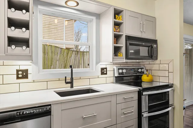 a kitchen with a sink and a stove next to a window