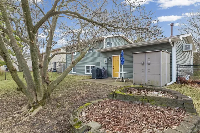 a view of a house with a yard tree and wooden fence