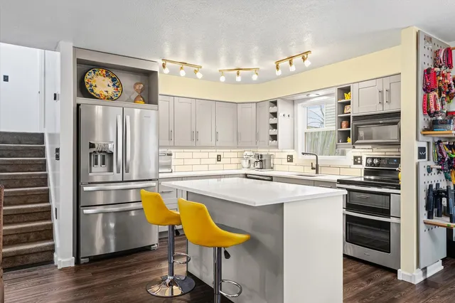 a kitchen with stainless steel appliances granite countertop a refrigerator and a stove top oven
