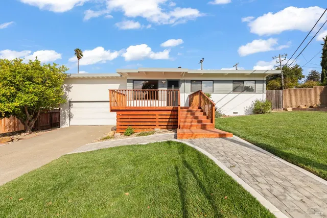 a front view of a house with a yard and a garage