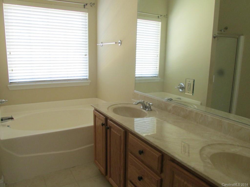 1842 Sam Smith Road, Unit 7 Fort Mill, SC 29708 - Photo 16 of 16 a bathroom with a granite countertop sink and a bathtub