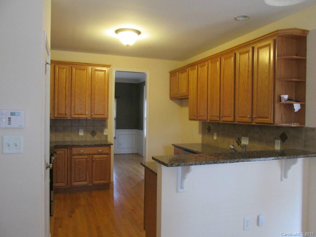 1842 Sam Smith Road, Unit 7 Fort Mill, SC 29708 - Photo 5 of 16 a kitchen with granite countertop a sink a stove and cabinets