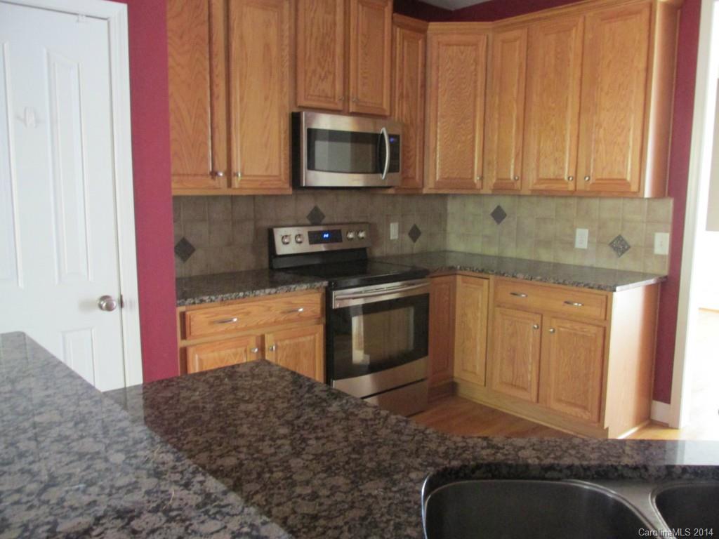 1842 Sam Smith Road, Unit 7 Fort Mill, SC 29708 - Photo 6 of 16 a kitchen with granite countertop a stove sink and cabinets