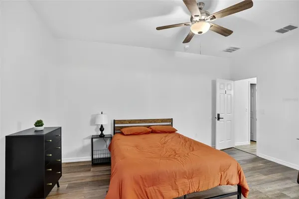 a bedroom with a bed and wooden floor