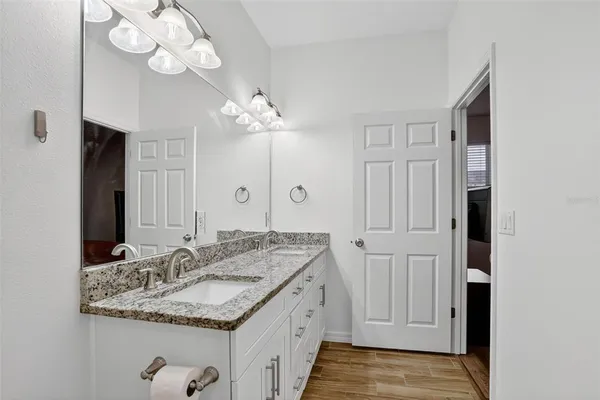 a bathroom with a granite countertop sink and a mirror