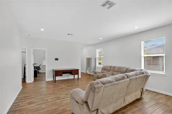 a living room with furniture and a wooden floor