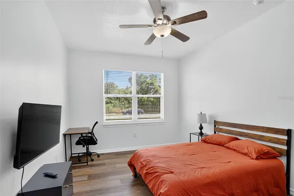 a bedroom with a bed tv and a window