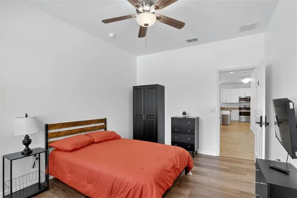 a bedroom with a bed and wooden floor