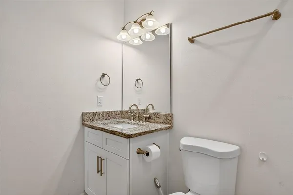 a bathroom with a sink vanity and a toilet