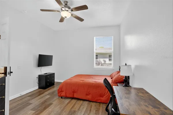 a bedroom with a bed and a flat tv screen on the dresser