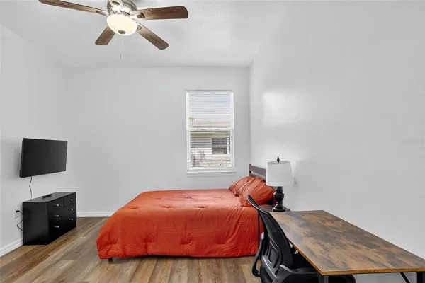 a bedroom with a bed and wooden floor