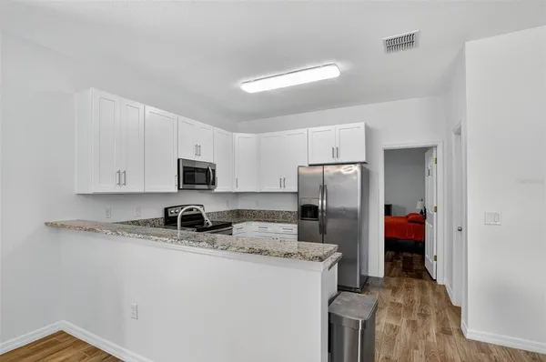 a kitchen with stainless steel appliances granite countertop a refrigerator and a stove