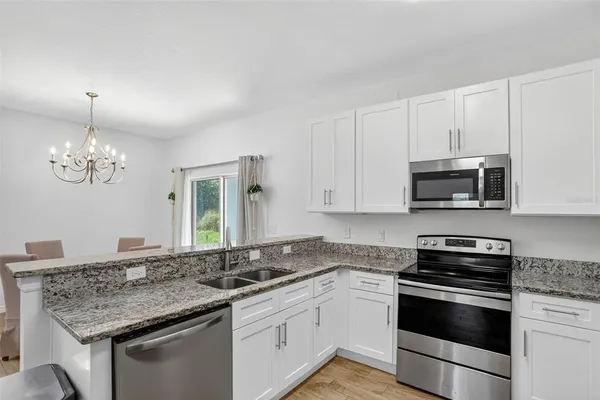 a kitchen with stainless steel appliances granite countertop a sink stove and microwave