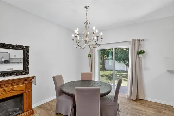 a dining room with furniture a chandelier and wooden floor