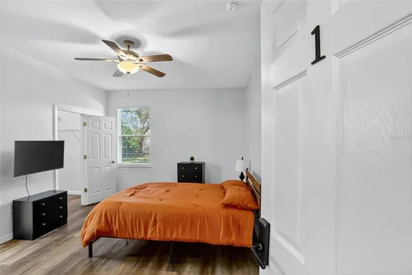 a bedroom with a bed and a flat tv screen on a dresser