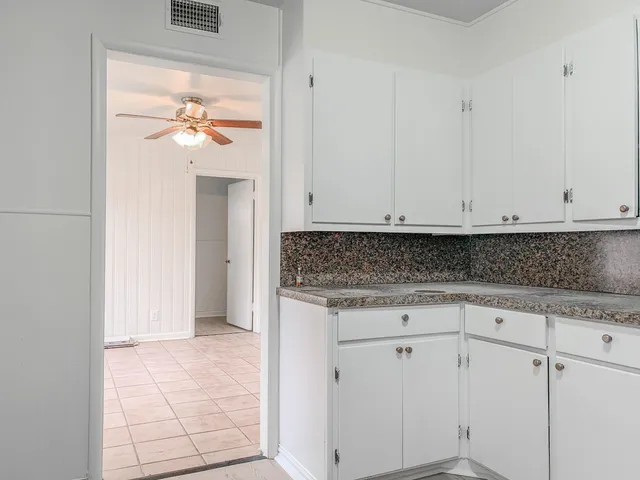 a view white cabinets and a painting on the wall