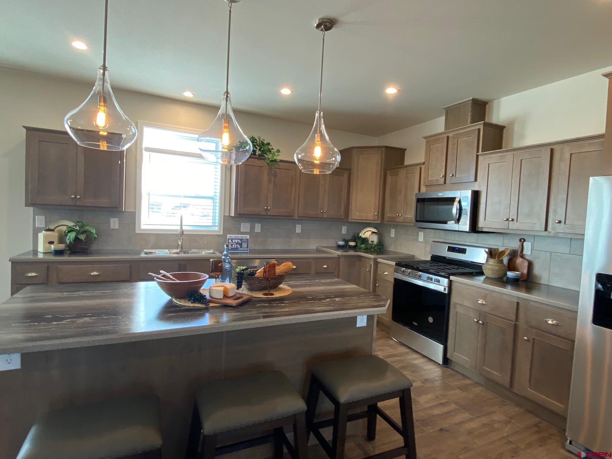 1230 H25 Road Delta, CO 81416 - Photo 8 of 34 a kitchen with a refrigerator a stove a sink and cabinets