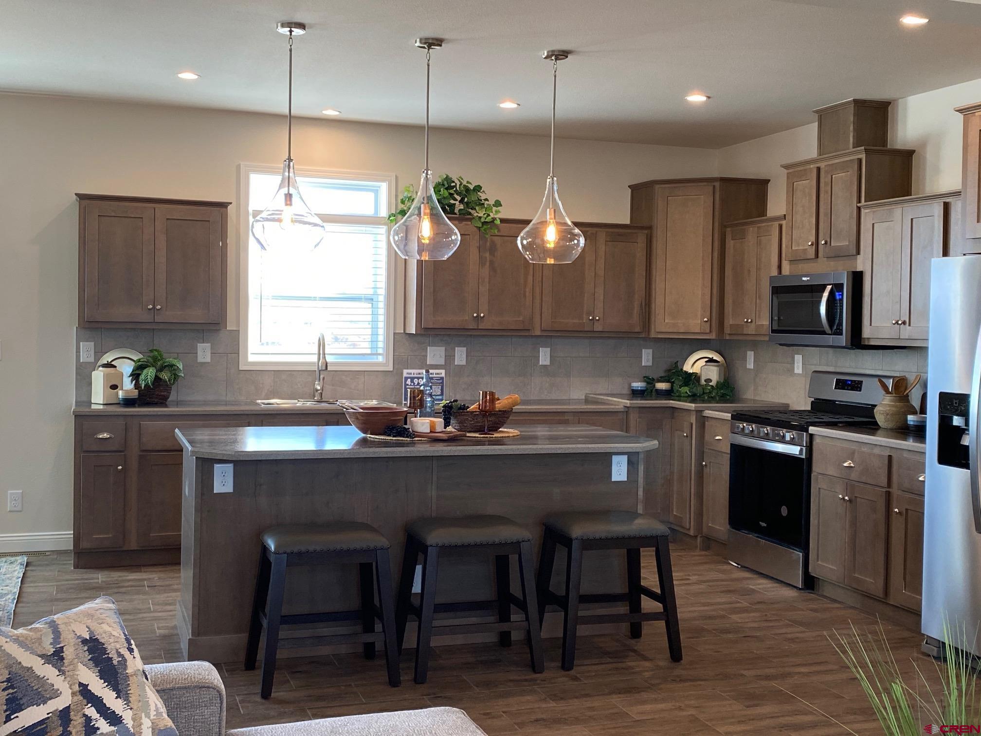 1230 H25 Road Delta, CO 81416 - Photo 9 of 34 a kitchen with stainless steel appliances granite countertop a sink a stove a refrigerator cabinets and chairs