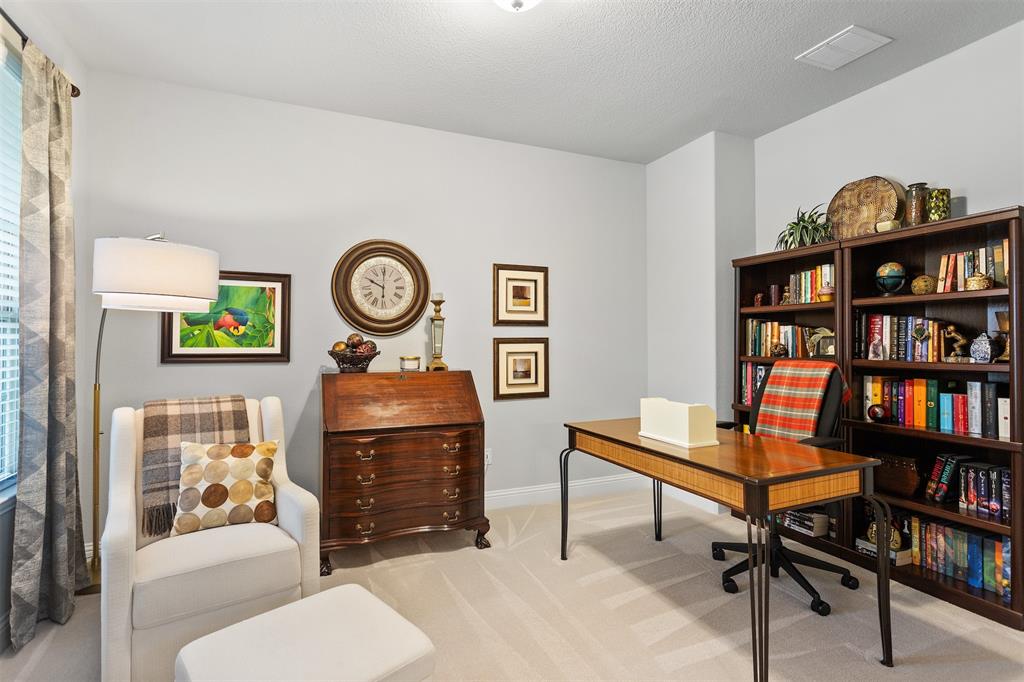 1003 Fenwick Lane Forney, TX 75126 - Photo 18 of 39 a living room with furniture a rug and a bookshelf