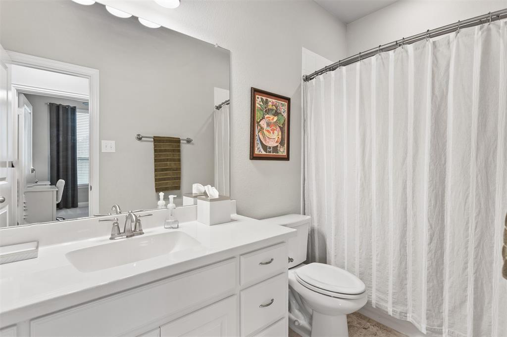 1003 Fenwick Lane Forney, TX 75126 - Photo 25 of 39 a bathroom with a sink a toilet and a mirror