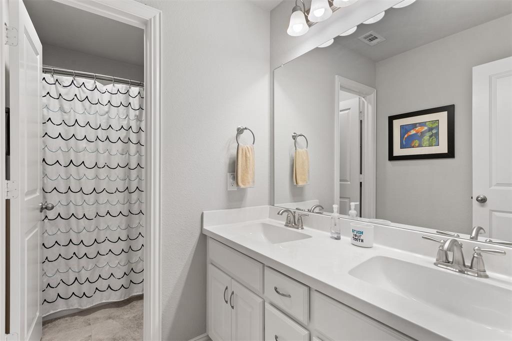 1003 Fenwick Lane Forney, TX 75126 - Photo 30 of 39 a bathroom with a sink a mirror a vanity and a shower