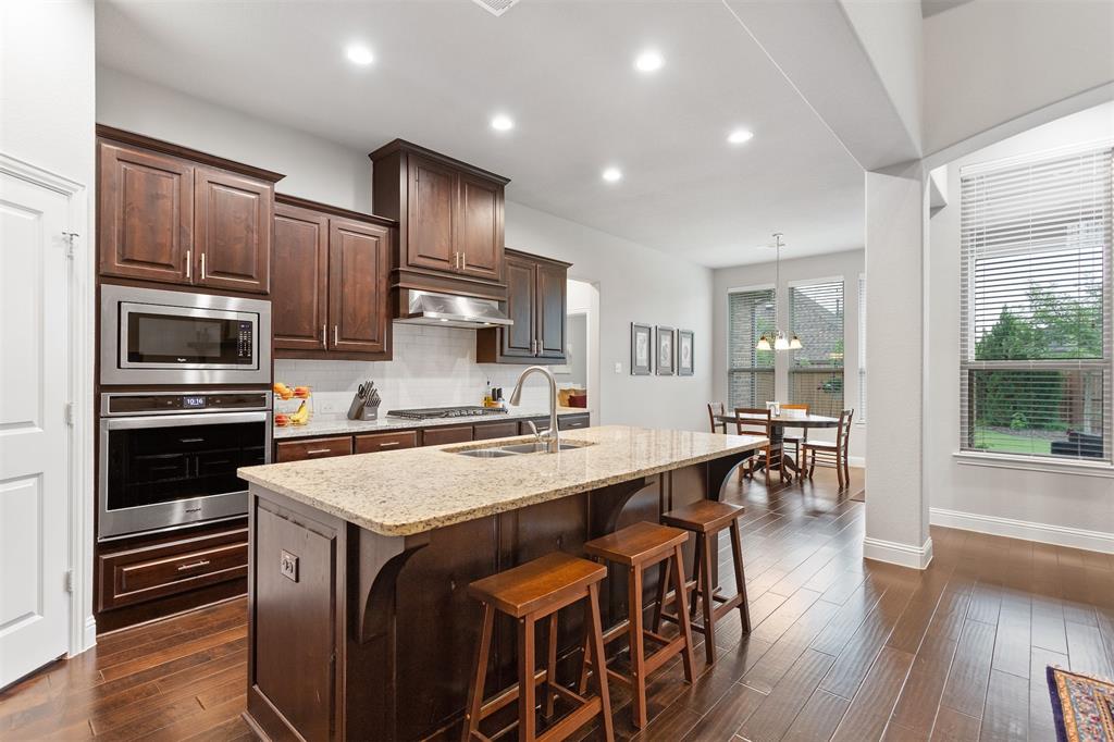 1003 Fenwick Lane Forney, TX 75126 - Photo 9 of 39 a kitchen with stainless steel appliances a stove a sink a microwave a refrigerator and cabinets