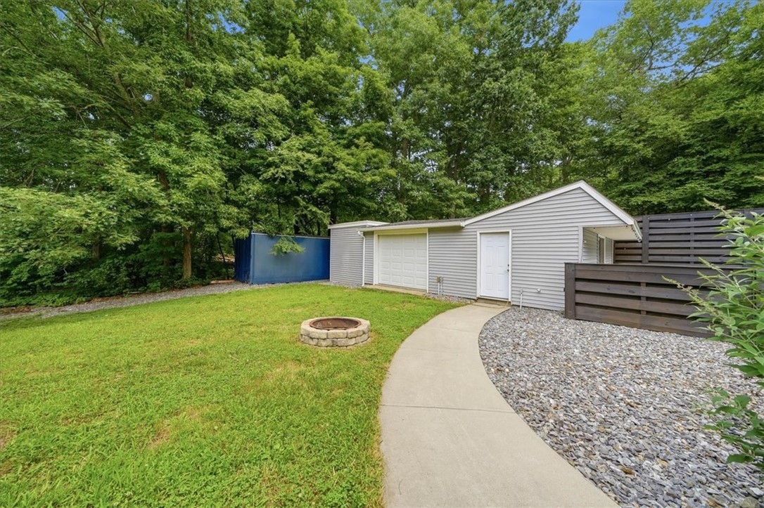 214 Anan Wade Road Glocester, RI 02857 - Photo 41 of 50 The backyard fun continues with a dedicated firepit area surrounded by lawn, mature trees and easy access to the pool house and detached garage.